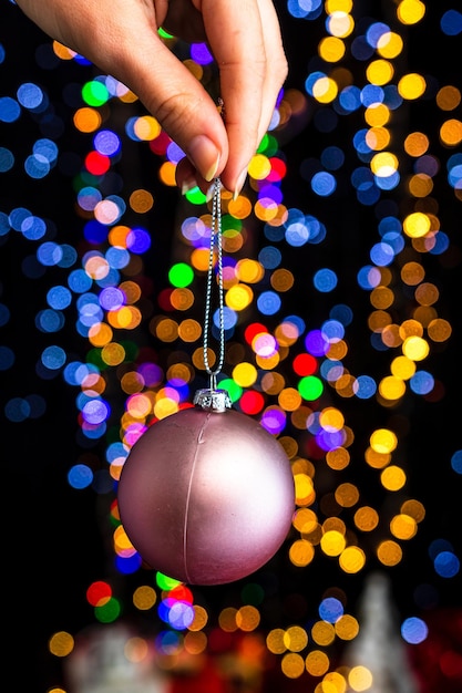 Foto close-up di una mano che tiene le luci di natale illuminate