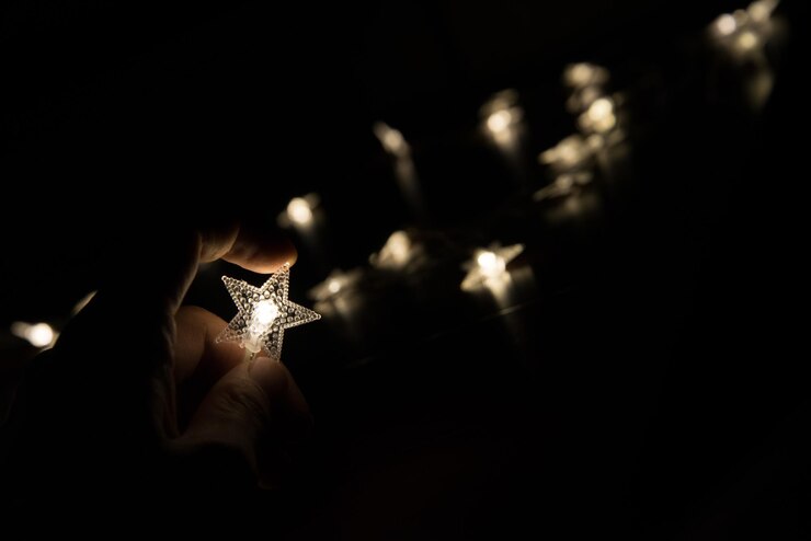 Photo 밝은 크리스마스 불빛을 들고 있는 손의 클로즈업