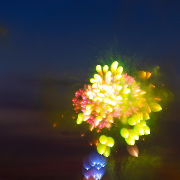 Foto close-up di una mano che tiene un fiore illuminato di notte