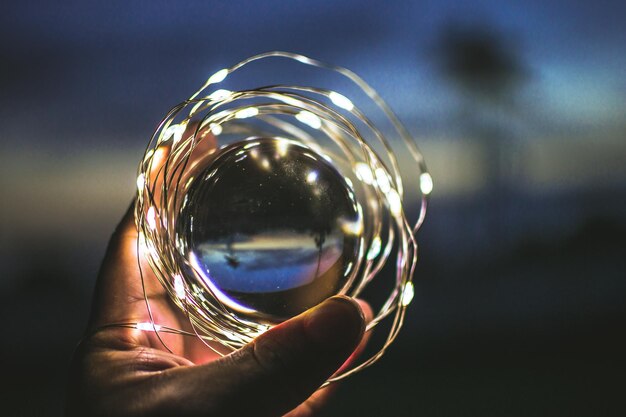 Foto prossimo piano di una lampada illuminata tenuta a mano