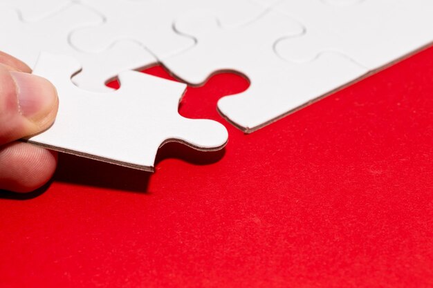 Foto close-up di un pezzo di puzzle tenuto in mano