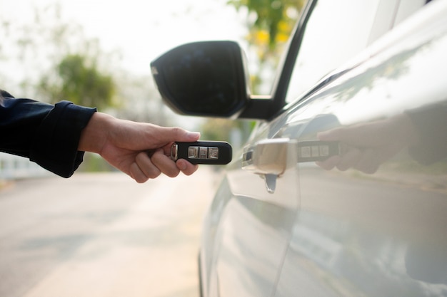 Close up hand holding key open car