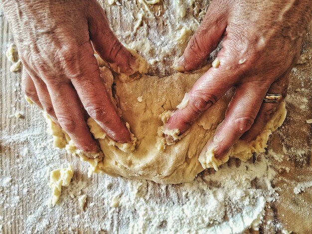 Close-up of hand holding meat on table