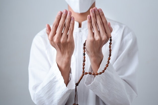 Close up Hand holding a muslim beads or tasbih with on grey