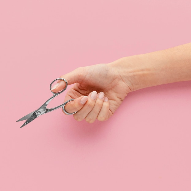 Photo close-up hand holding nail scissors