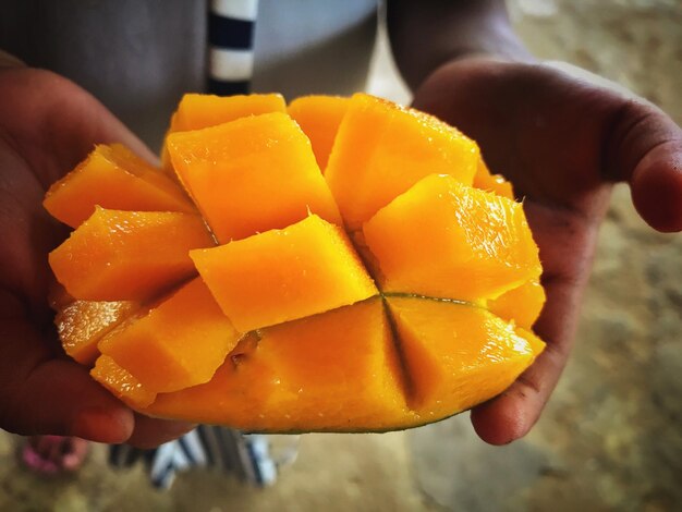 Close-up of hand holding orange fruit