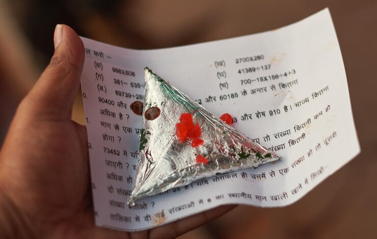 फोटो close-up of hand holding paan in paper