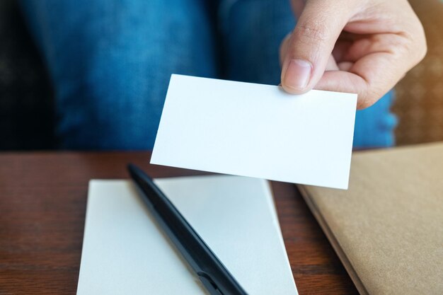 Photo close-up of hand holding paper with text on table