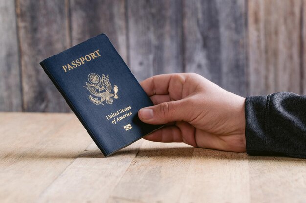 Foto close-up della mano che tiene il passaporto sul tavolo