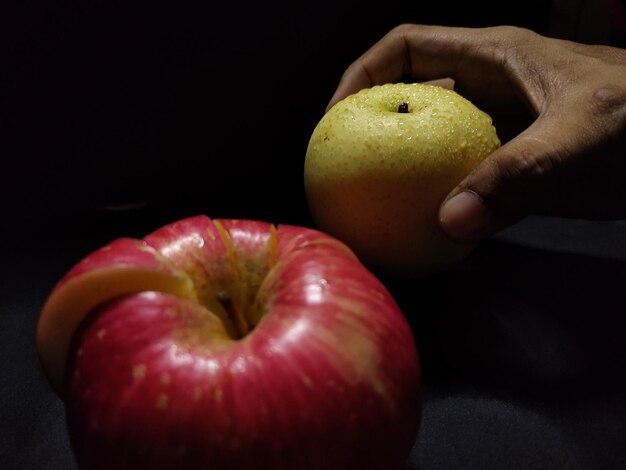 Photo close-up of hand holding pear