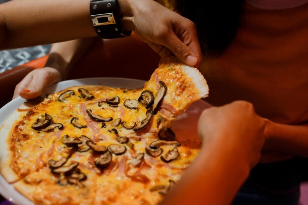 Photo close-up of hand holding pizza