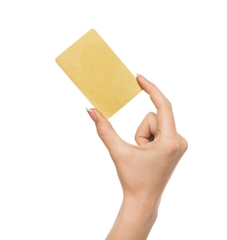 Primo piano mano che tiene la carta di credito in plastica, donna che mostra biglietto da visita bianco su sfondo bianco studio isolato, spazio copia, ritaglio