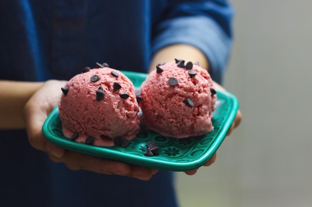 close-up of hand holding a plate with ice cream