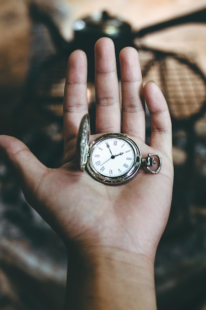 close-up of hand holding pocket watch