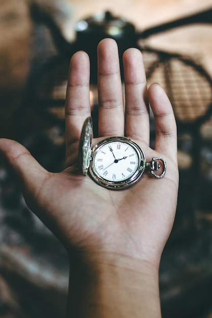 Foto close-up di un orologio da tasca tenuto in mano