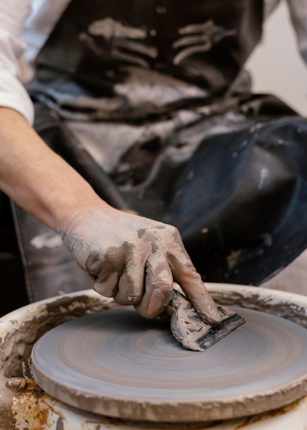 Close-up hand holding pottery tool