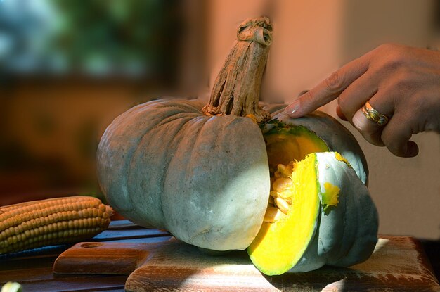 Photo close-up of hand holding pumpkin on table