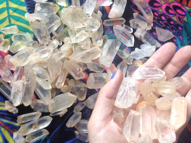 Photo close-up of hand holding quartz at table