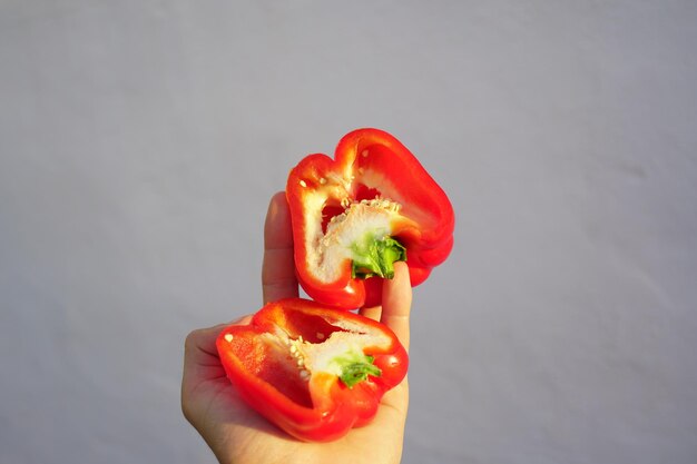 Close-up of hand holding red bell pepper