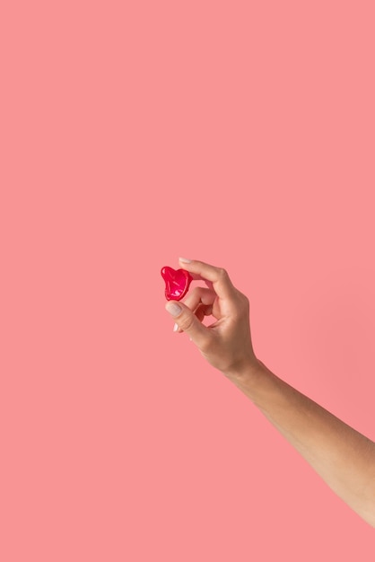 Close up hand holding red condom