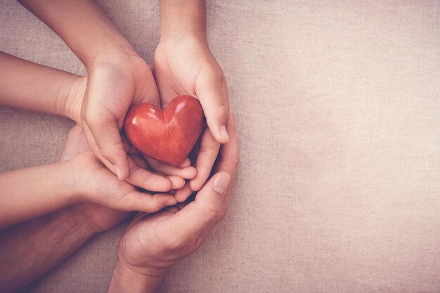 Foto close-up di una mano in forma di cuore rosso