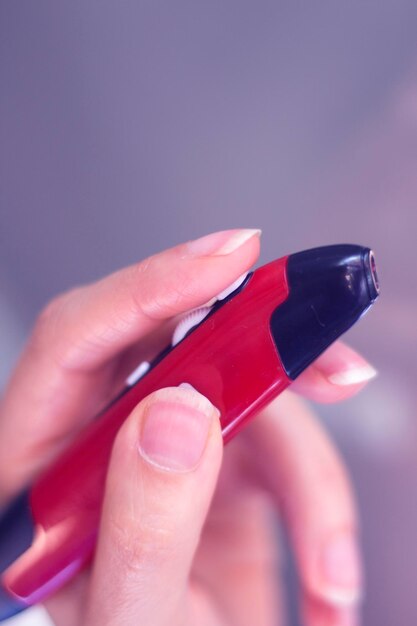 Close-up of hand holding red mouse pen