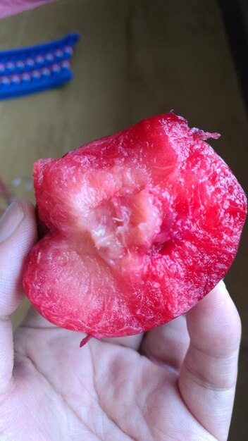 Close-up of hand holding red strawberries