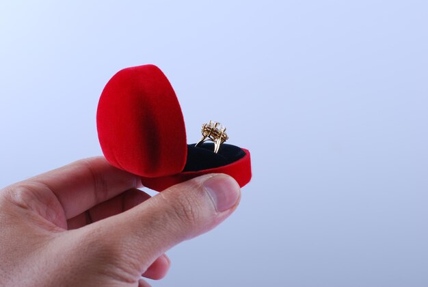 Photo close-up of hand holding red wine against white background