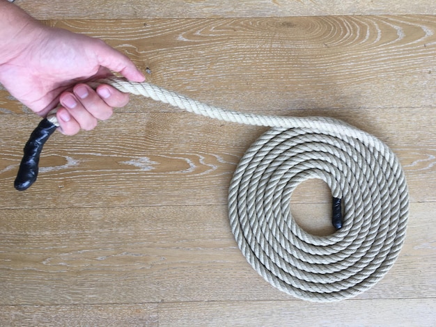 Close-up of hand holding rope on table