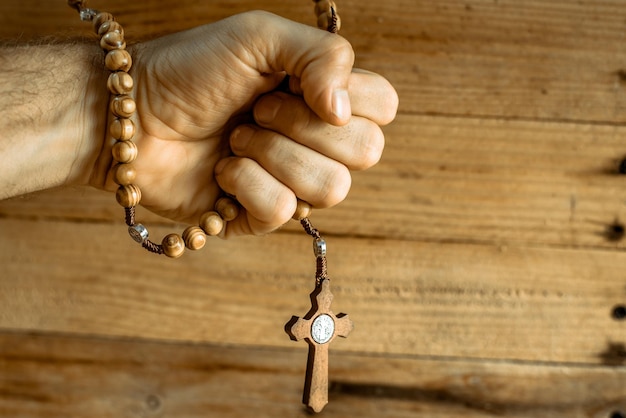 Photo close-up of hand holding rosary