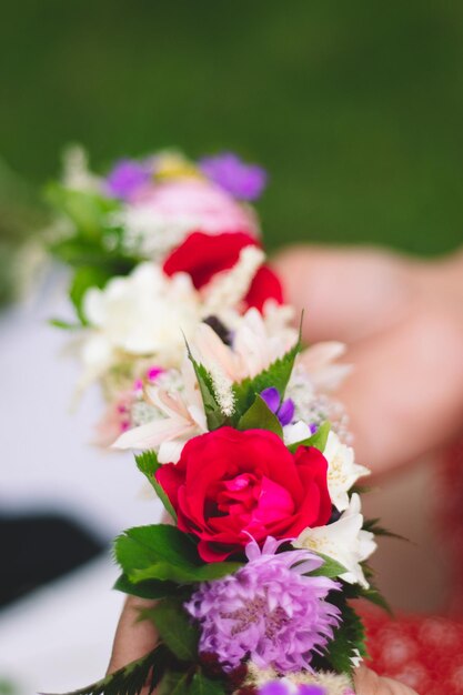 Foto close-up di una mano che tiene un bouquet di rose