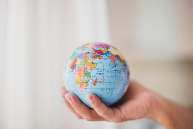 Close-up of hand holding small globe