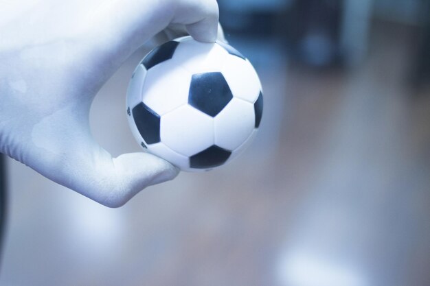 Foto close-up di una mano che tiene una palla da calcio