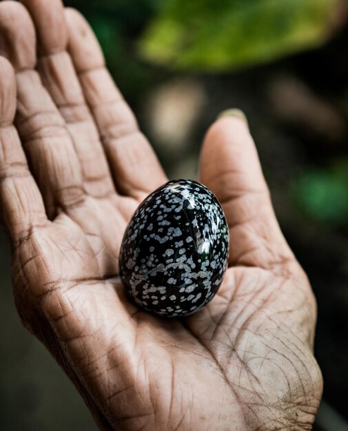 Close-up of hand holding sphere shape object