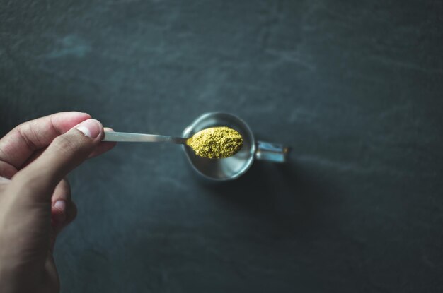 Photo close-up of hand holding spoon