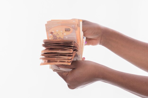 Close-up of hand holding stack against white background