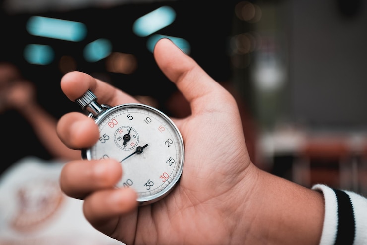 Photo close-up of hand holding stopwatch