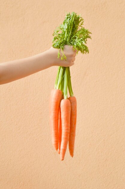 Close-up of hand holding strawberry over white background