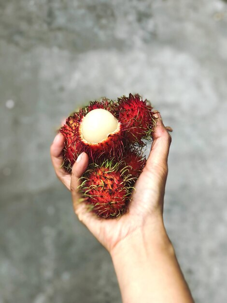 Photo close-up of hand holding strawberry