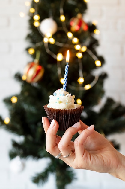 Photo close up hand holding tasty cupcake