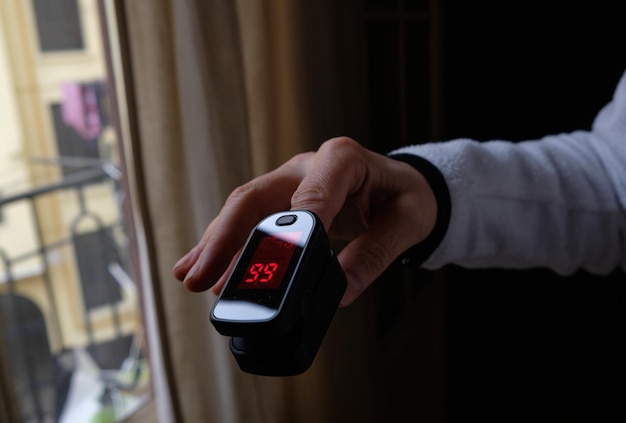 Photo close-up of hand holding thermometer