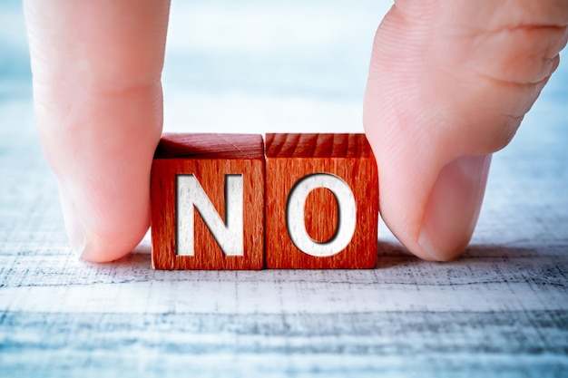 close-up of hand holding toy block with alphabets on table