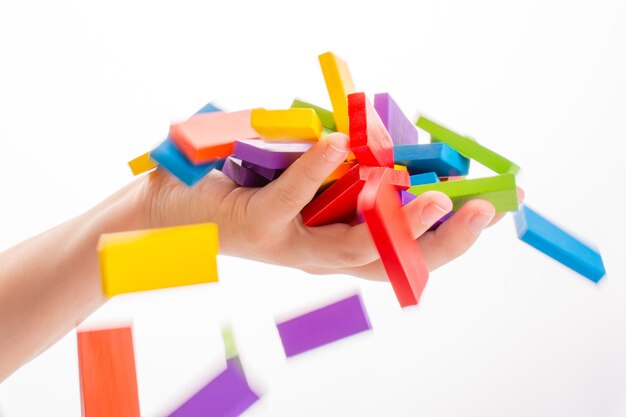 Photo close-up of hand holding toy blocks against white background