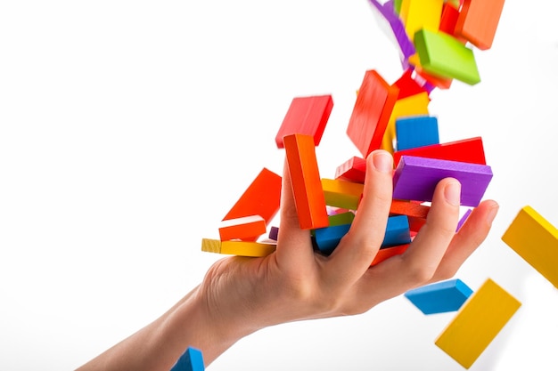 Photo close-up of hand holding toy blocks over white background