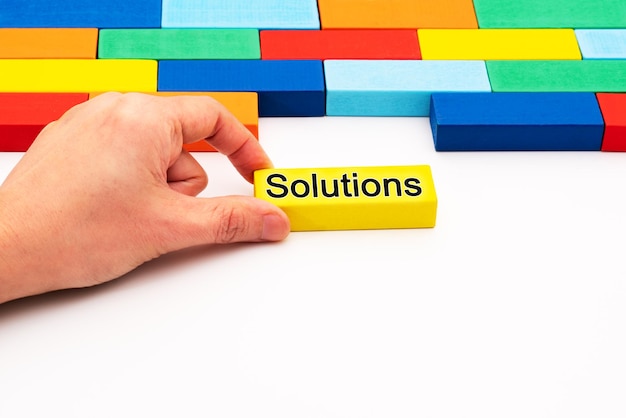 Photo close-up of hand holding toy blocks on white background