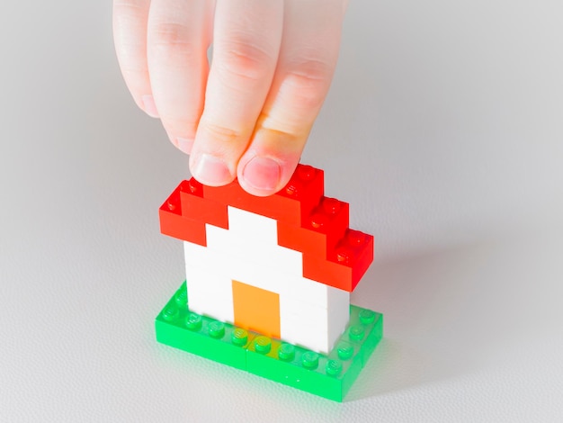 Close-up of hand holding toy on gray background