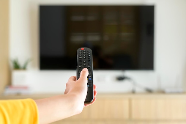 Close up of hand holding tv remote controller