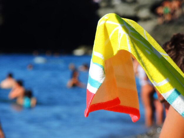 Close-up of hand holding umbrella over swimming pool