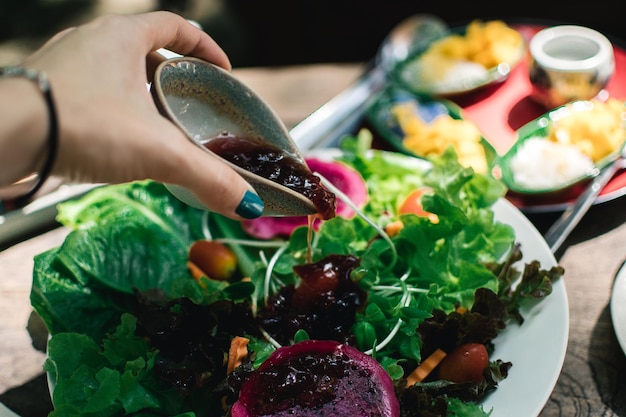 Photo close-up of hand holding vegetables on table