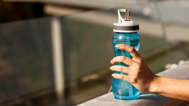 Photo close-up of hand holding water bottle